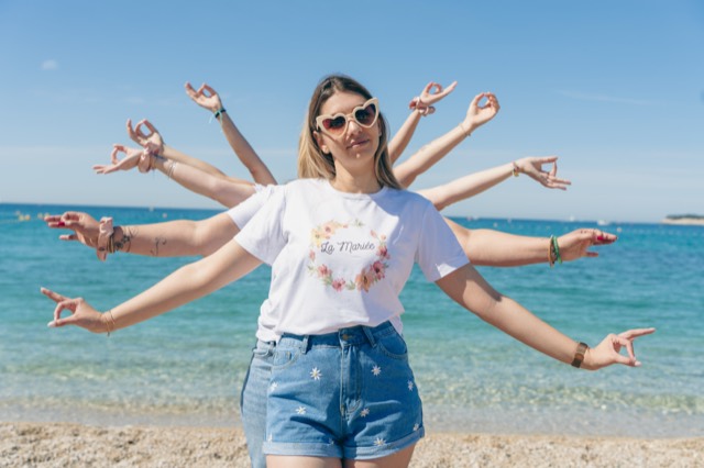 Future mariée et ses amies formant une figure à mille bras sur la plage