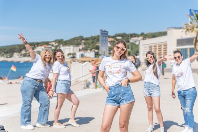 Bande d'amies posant sur la promenade en bord de mer pour un EVJF