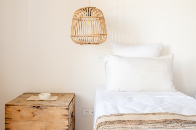 Chambre cosy avec tête de lit en bois — photographie immobilière HD