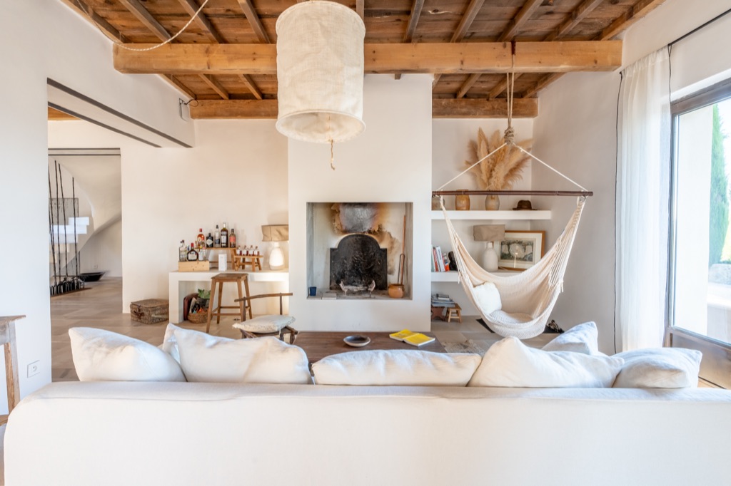 Salon de mas provençal aux poutres apparentes avec cheminée — photographie immobilière professionnelle
