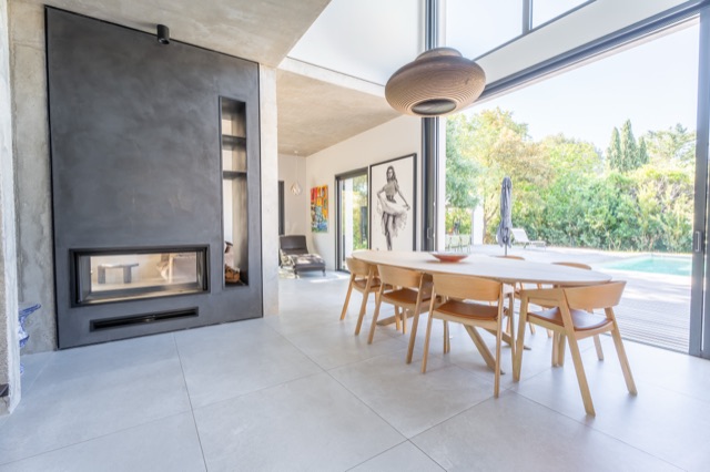 Salle à manger de villa d'architecte avec cheminée suspendue — photographe immobilier
