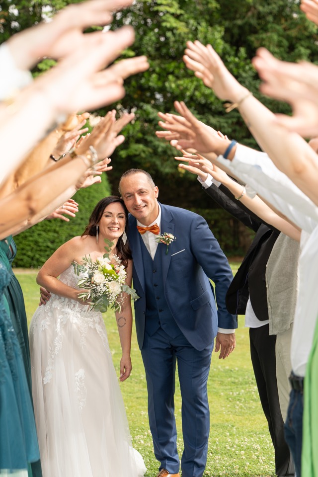 Les mariés sous une haie d'honneur lors de leur mariage
