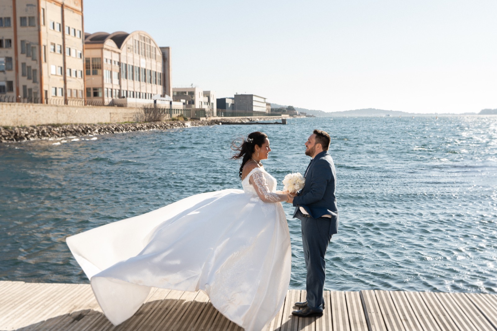 Couple de mariés au bord de l'eau dans la lumière dorée — photographe mariage Aix-en-Provence