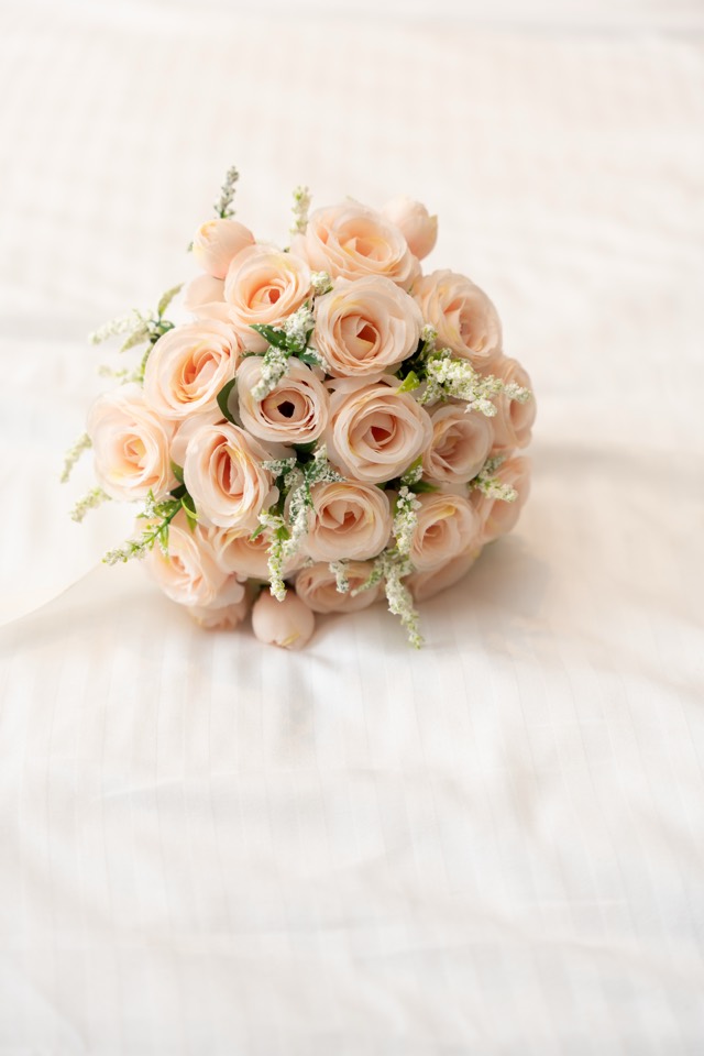 Bouquet de mariée aux roses pâles posé délicatement